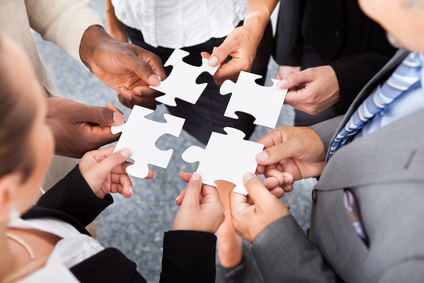 businesspeople holding jigsaw puzzle